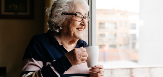 zufriedene ältere Dame schaut aus dem Fenster